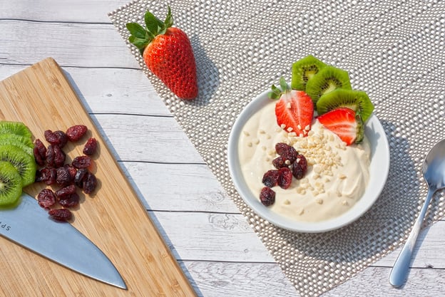 bowl of yoghurt with kiwi fruit, strawberries and cranberries 