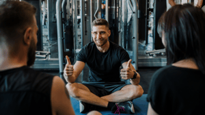 Personal trainer looking at clients giving thumbs up 