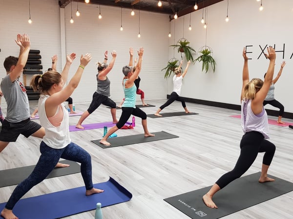 People on yoga mats doing yoga pose 