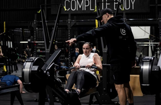 Image of women and trainer on rowing machine 